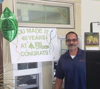 Man standing in front of a sign and a balloon