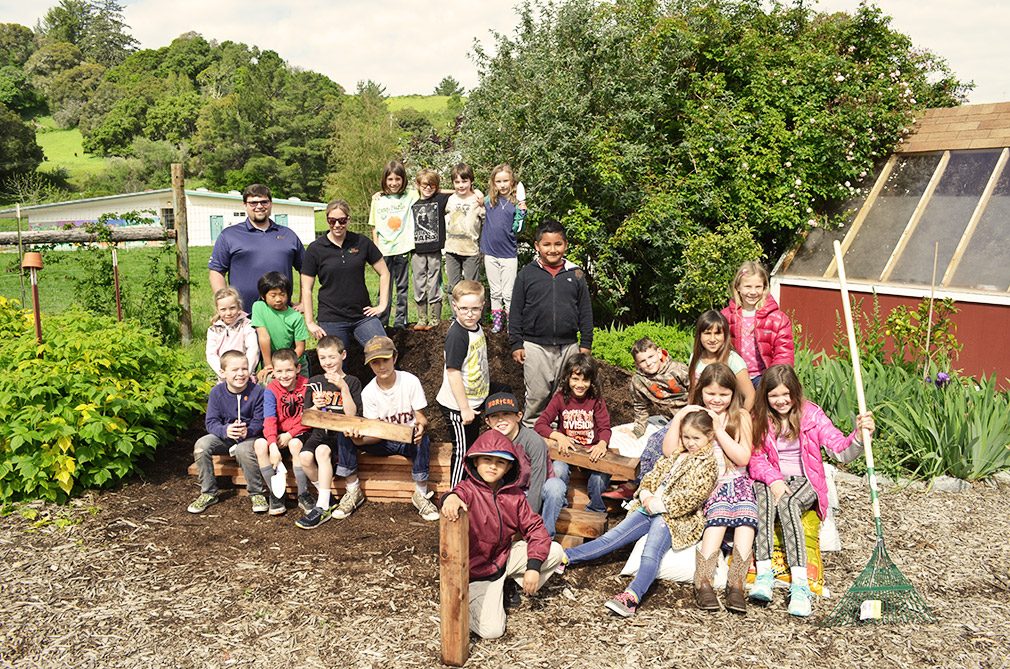 Children with garden bed donation.