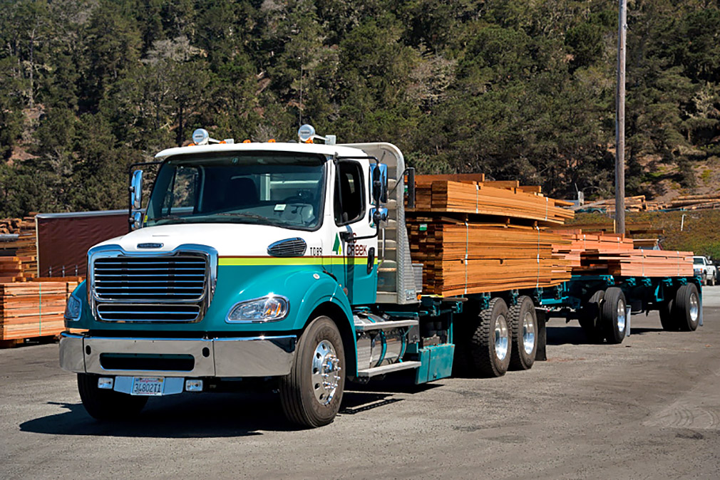 Flatbed truck and trailer with redwood boards.