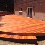 Curved redwood deck with step.