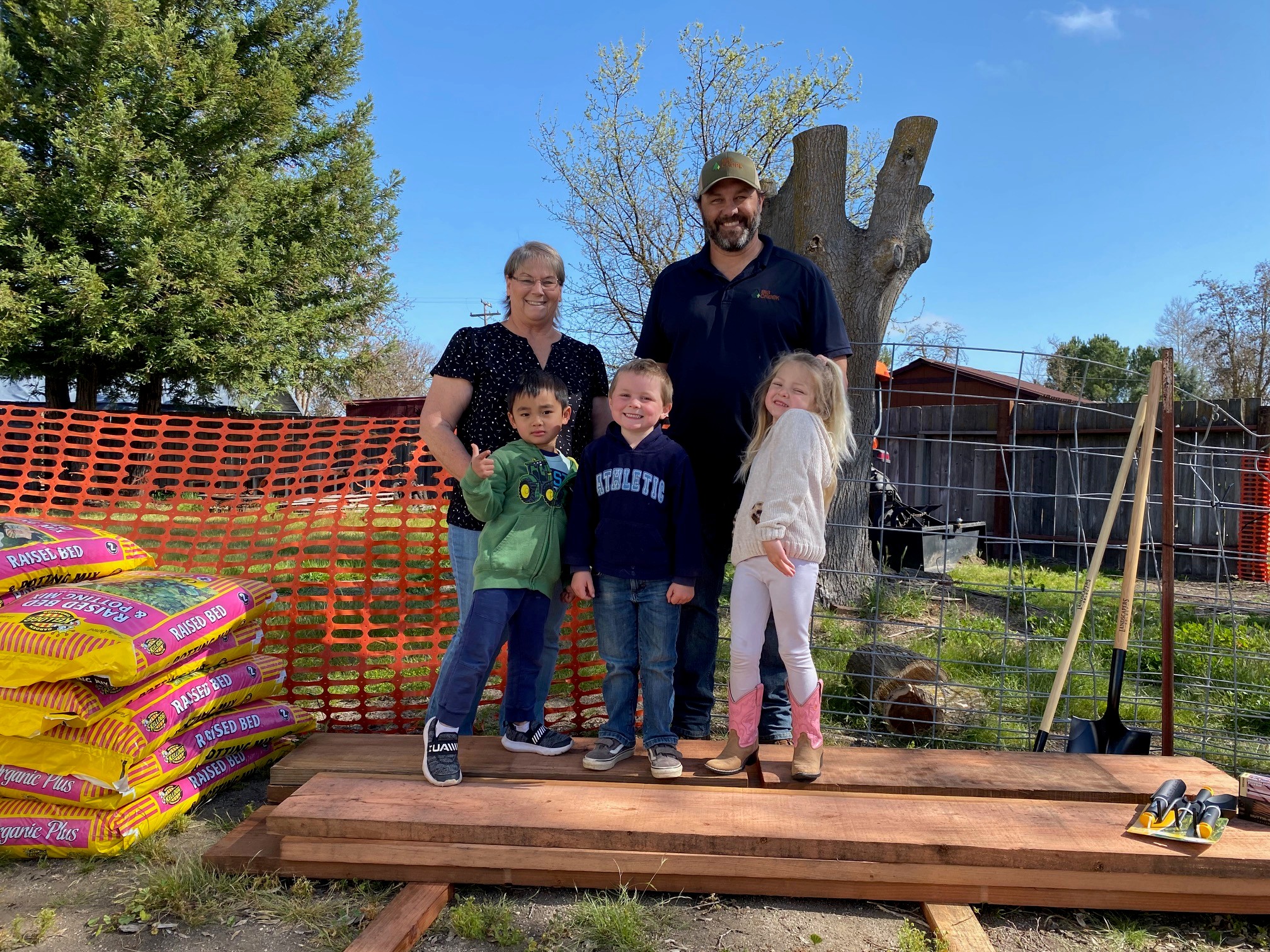Kids and teacher with school garden bed grant lumber