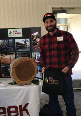 Customer standing in front of prize and redwood round