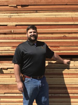 Man Standing In Fromt of Lumber