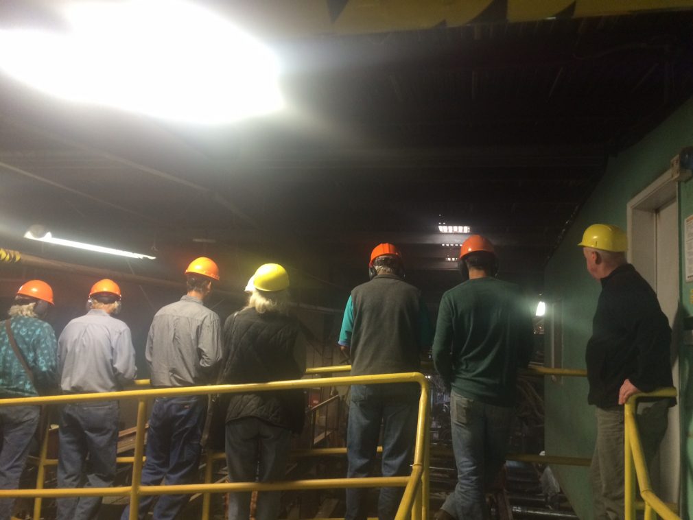 People with hardhats touring sawmill