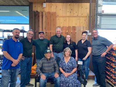 Big Creek Lumber Co-Founder Lud McCrary sits on a bench with the team of Big Creek Vallejo 