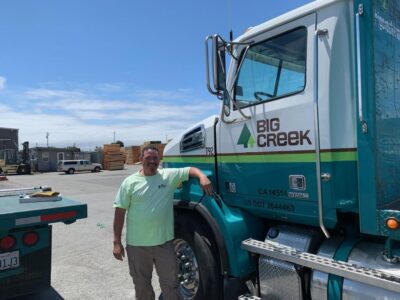 Man standing leaning on Big Creek Truck 