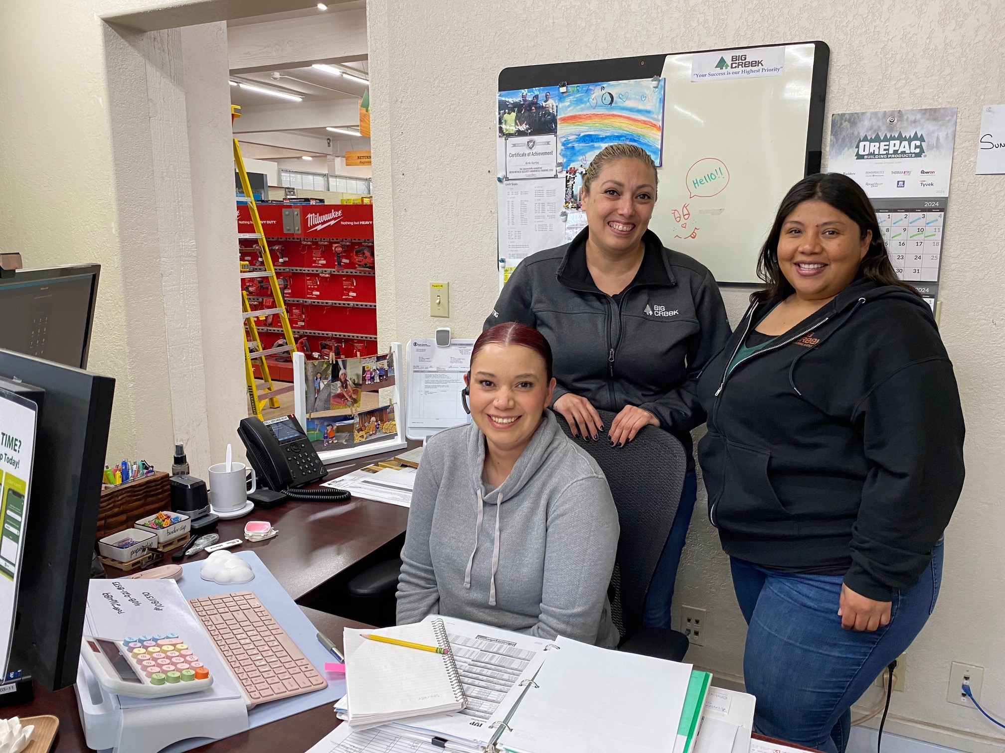 Three sales team members standing behind a desk