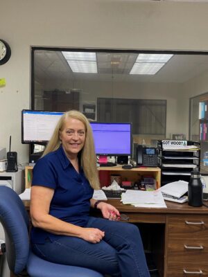 Woman siting in front of a desk smiling