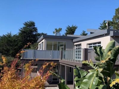 House with deck and windows and plants in front of camera lens